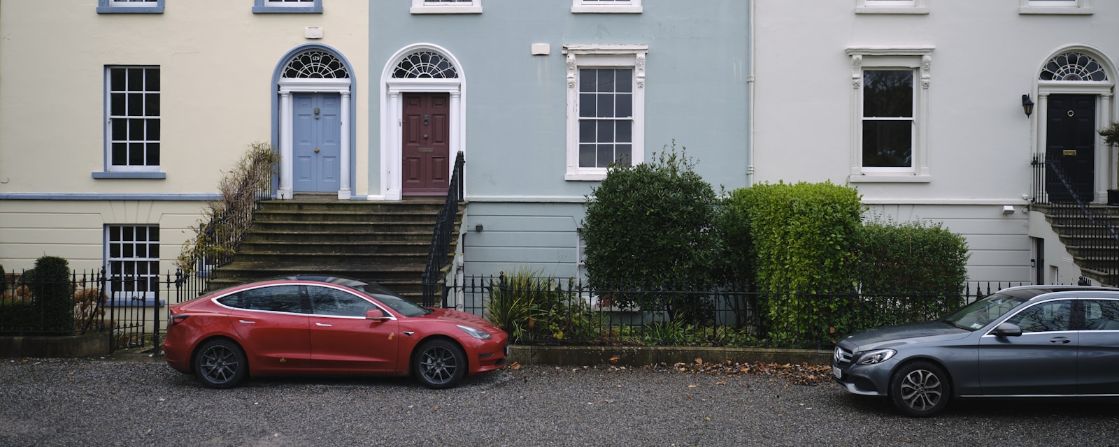 A terrace of Georgian houses with fanlight doors and iron railings on an Irish street