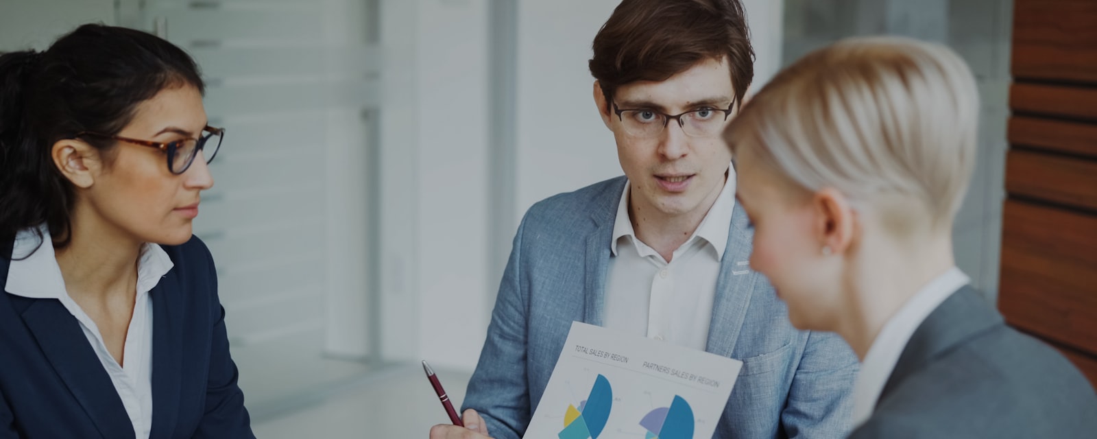 A wealth adviser presenting portfolio analysis to two clients